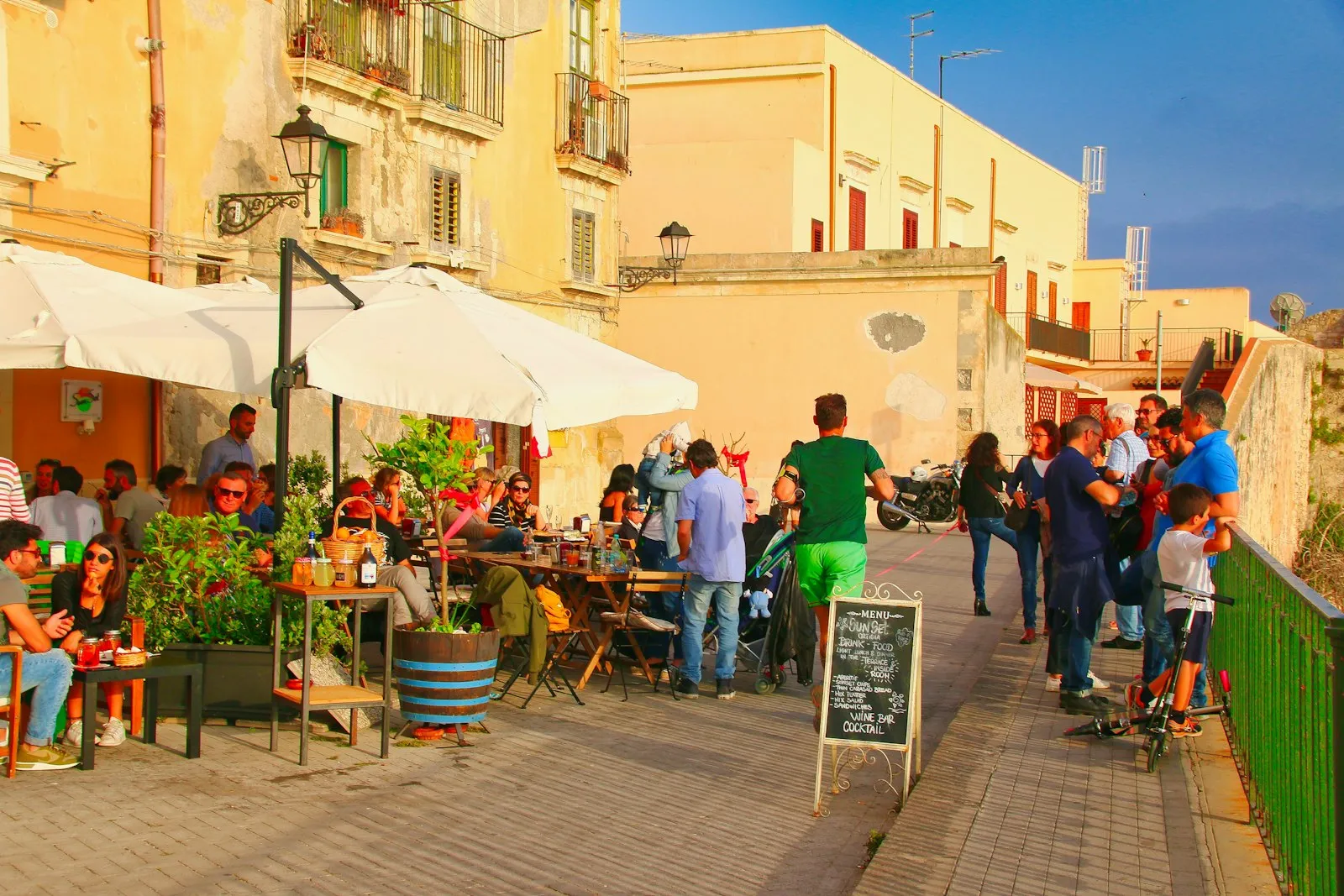 Terrasse ensoleillée avec personnes qui déjeunent
